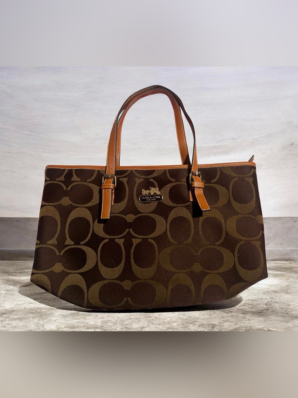 brown Coach signature canvas tote bag with tan leather trim.